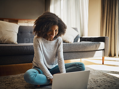 Buy stock photo Shot of an attractive young woman using a laptop at home