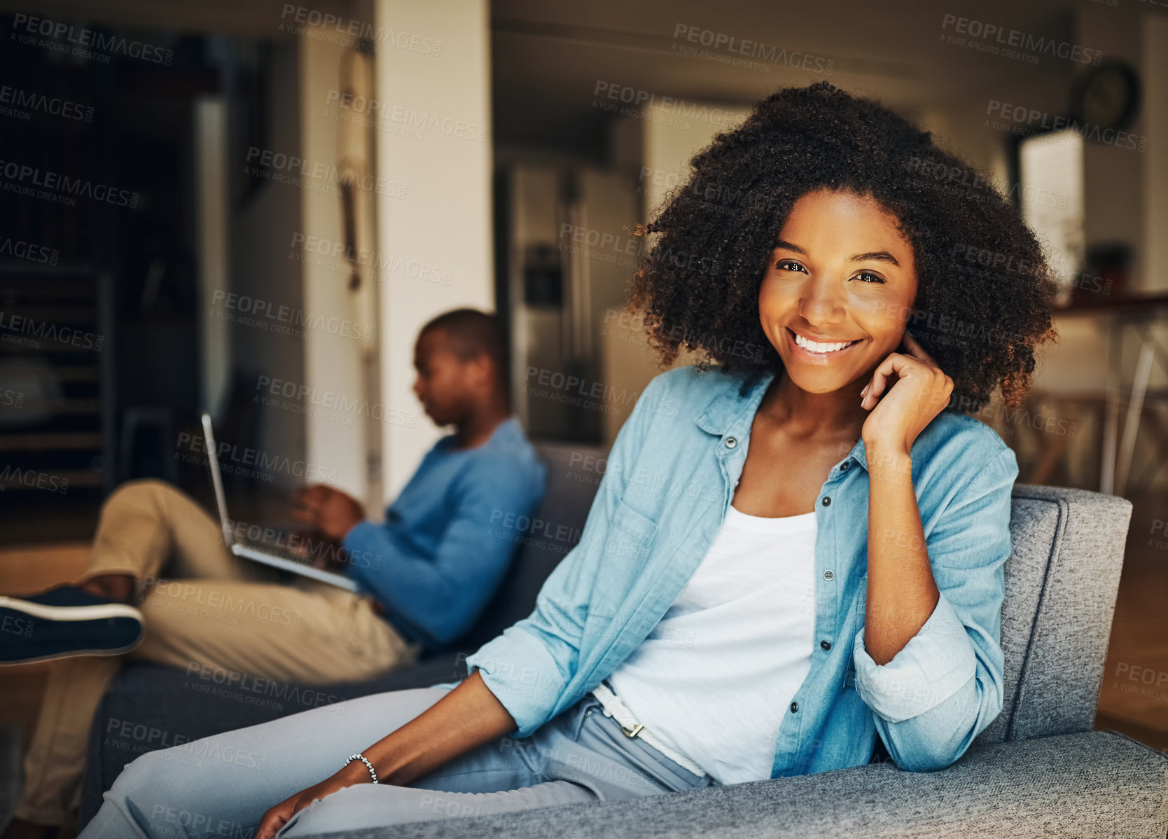 Buy stock photo Shot of a young woman relaxing at home with her boyfriend in the background