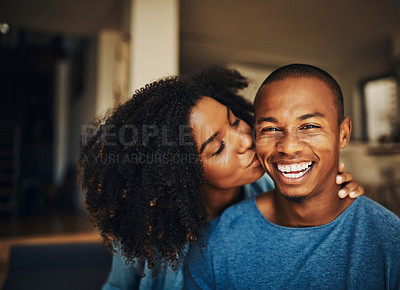 Buy stock photo Shot of an affectionate young couple relaxing at home