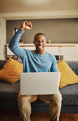 Buy stock photo Portrait of a handsome young man cheering while working on a laptop at home
