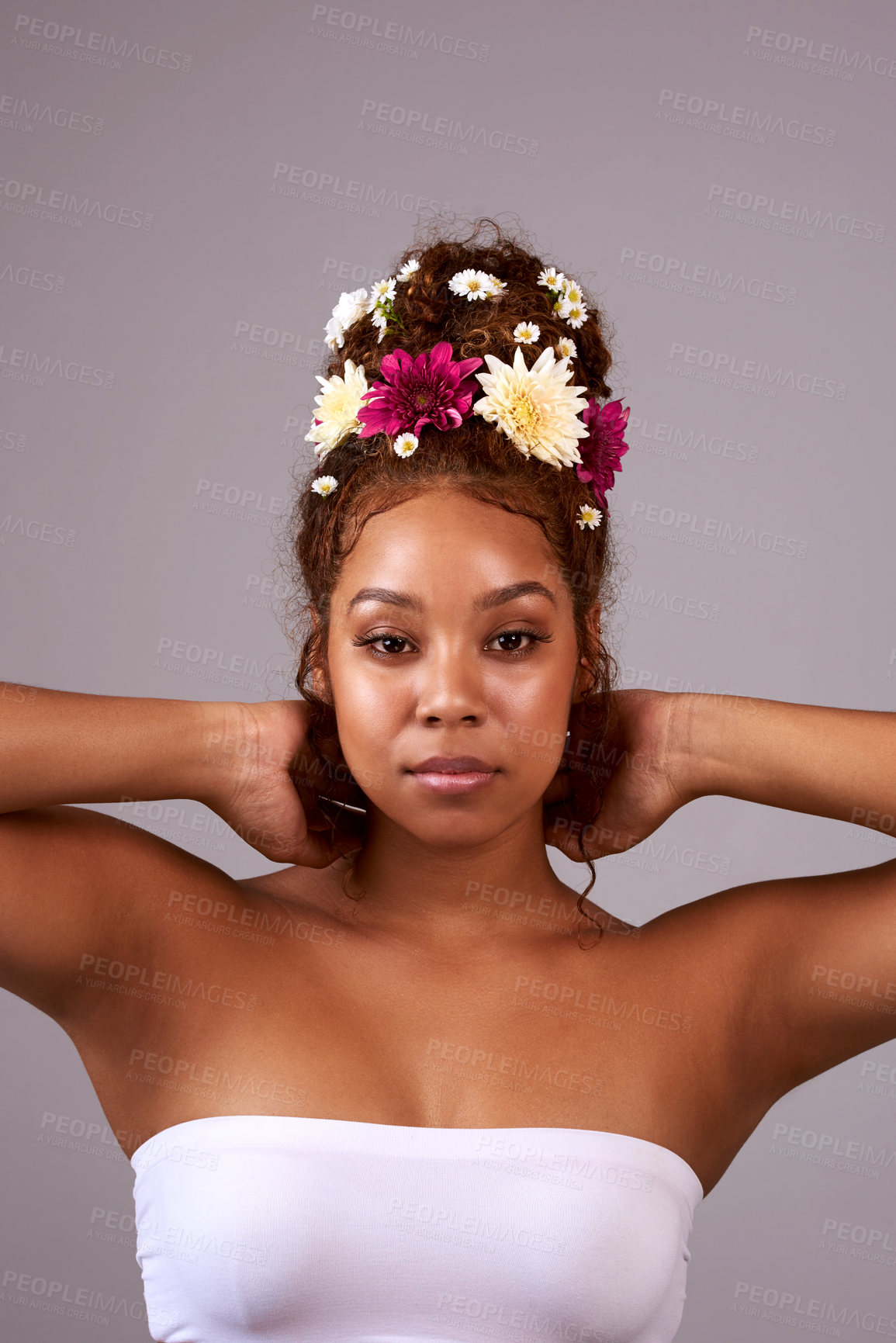 Buy stock photo Studio shot of a beautiful young woman with flowers in her hair against a gray background