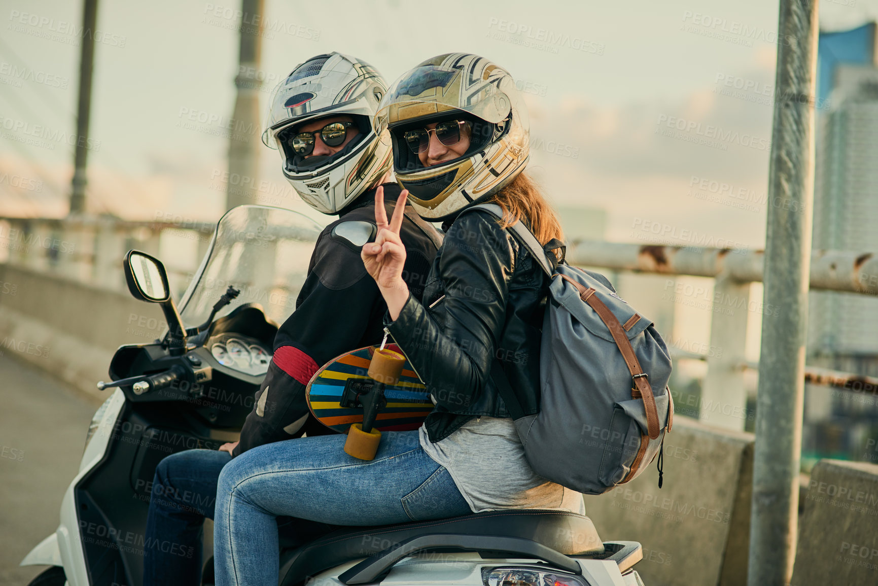 Buy stock photo Cropped shot of a young attractive couple riding a scooter around town