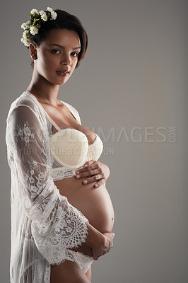 Buy stock photo Studio shot of a beautiful young pregnant woman posing against a gray background