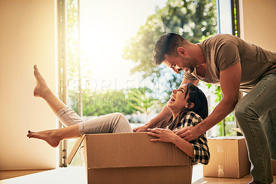 Buy stock photo Shot of a young couple having fun while moving into their new place