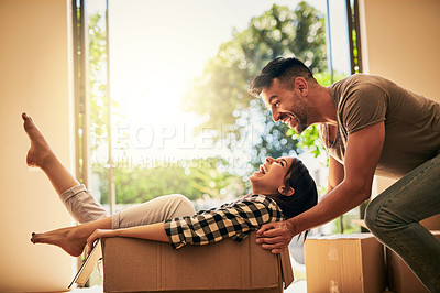 Buy stock photo New house, funny and couple pushing box, having fun and bonding in apartment. Real estate, laughing and man and woman in cardboard, play and enjoying quality time together while moving into property.
