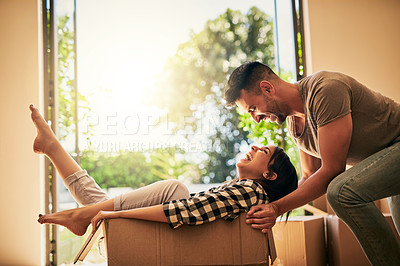 Buy stock photo New home, funny and couple pushing box, having fun and bonding in apartment. Real estate, laughing and man and woman in cardboard, play and enjoying quality time together while moving into property.