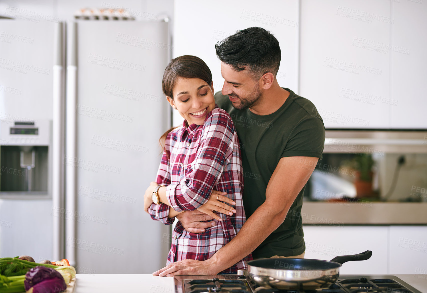 Buy stock photo Cropped shot of a young attractive couple cooking together in the kitchen at home