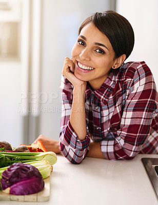 Buy stock photo Cropped shot of an attractive young woman cooking in the kitchen at home