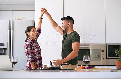 Buy stock photo Cropped shot of a young attractive couple cooking together in the kitchen at home