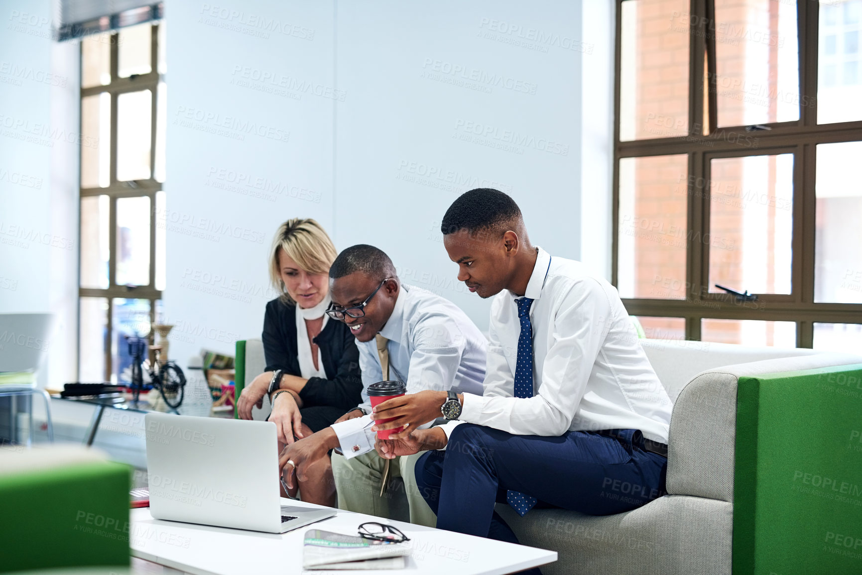 Buy stock photo Shot of a group of businesspeople working together on a laptop in an office