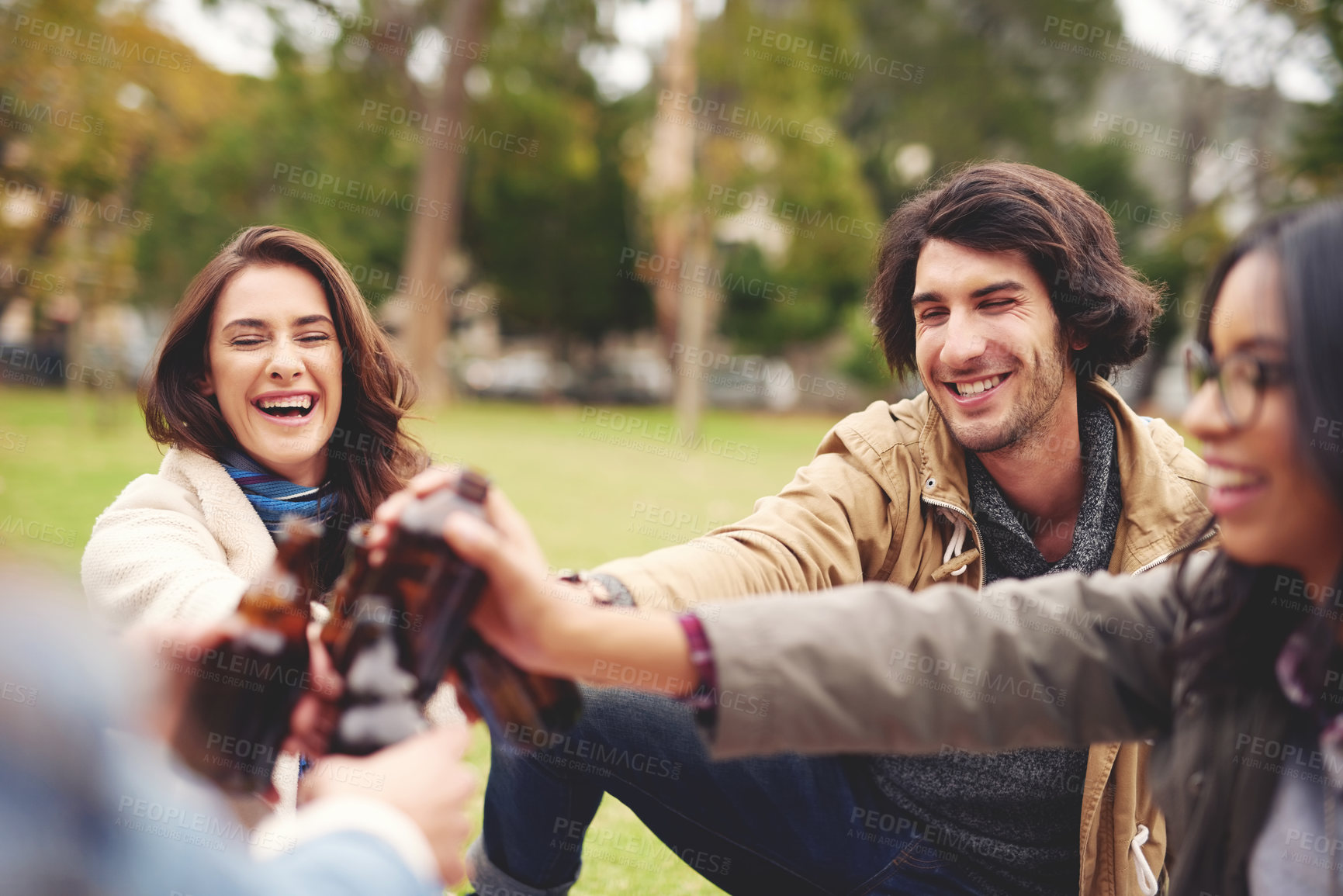 Buy stock photo Nature, smile and friends with beer for toast, celebration and bonding together in social gathering. Group, happy people and bottles with alcohol for achievement, reunion and cheers in outdoor picnic