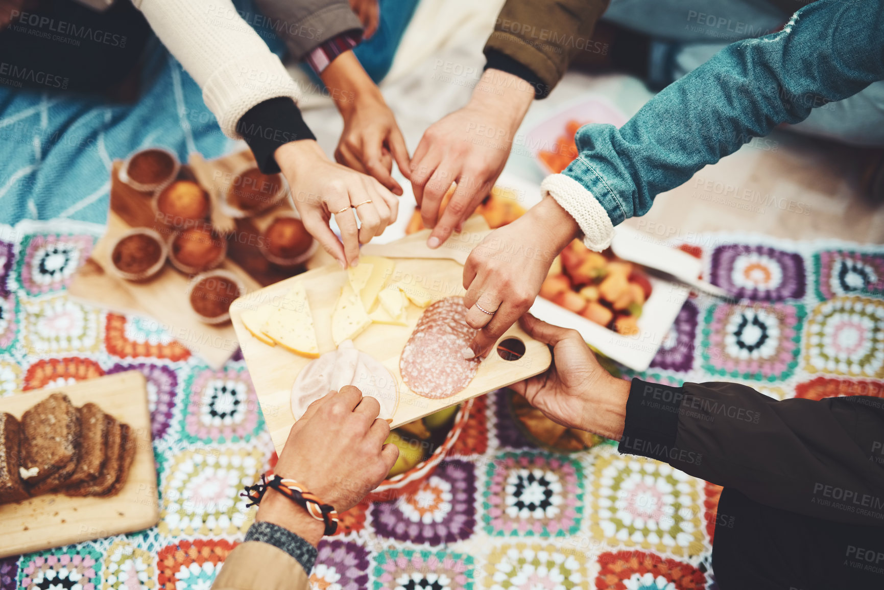 Buy stock photo Shot of a group of unrecognizable people's hands taking food from a plate at a picnic outside during the day