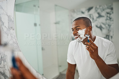 Buy stock photo Black man, smile and shaving with razor, foam or grooming in mirror for self care in home bathroom. African guy, soap or cream for facial hair removal, beard or clean for hygiene in morning at house