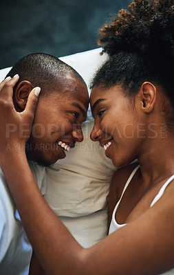 Buy stock photo High angle shot of a happy young couple sharing an affectionate moment together in bed