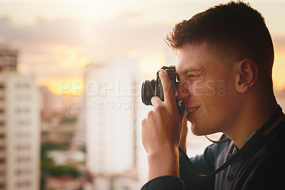Buy stock photo Cropped shot of a young man taking photographs of the city with a camera outside