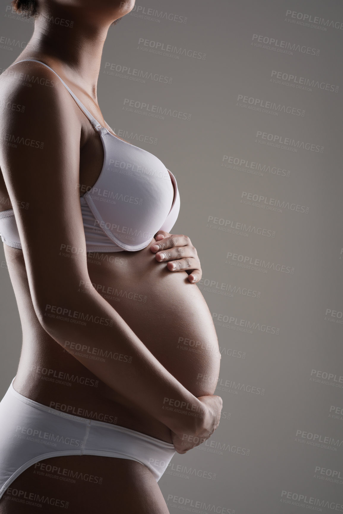 Buy stock photo Cropped studio shot of a pregnant woman wearing wearing underwear against a gray background