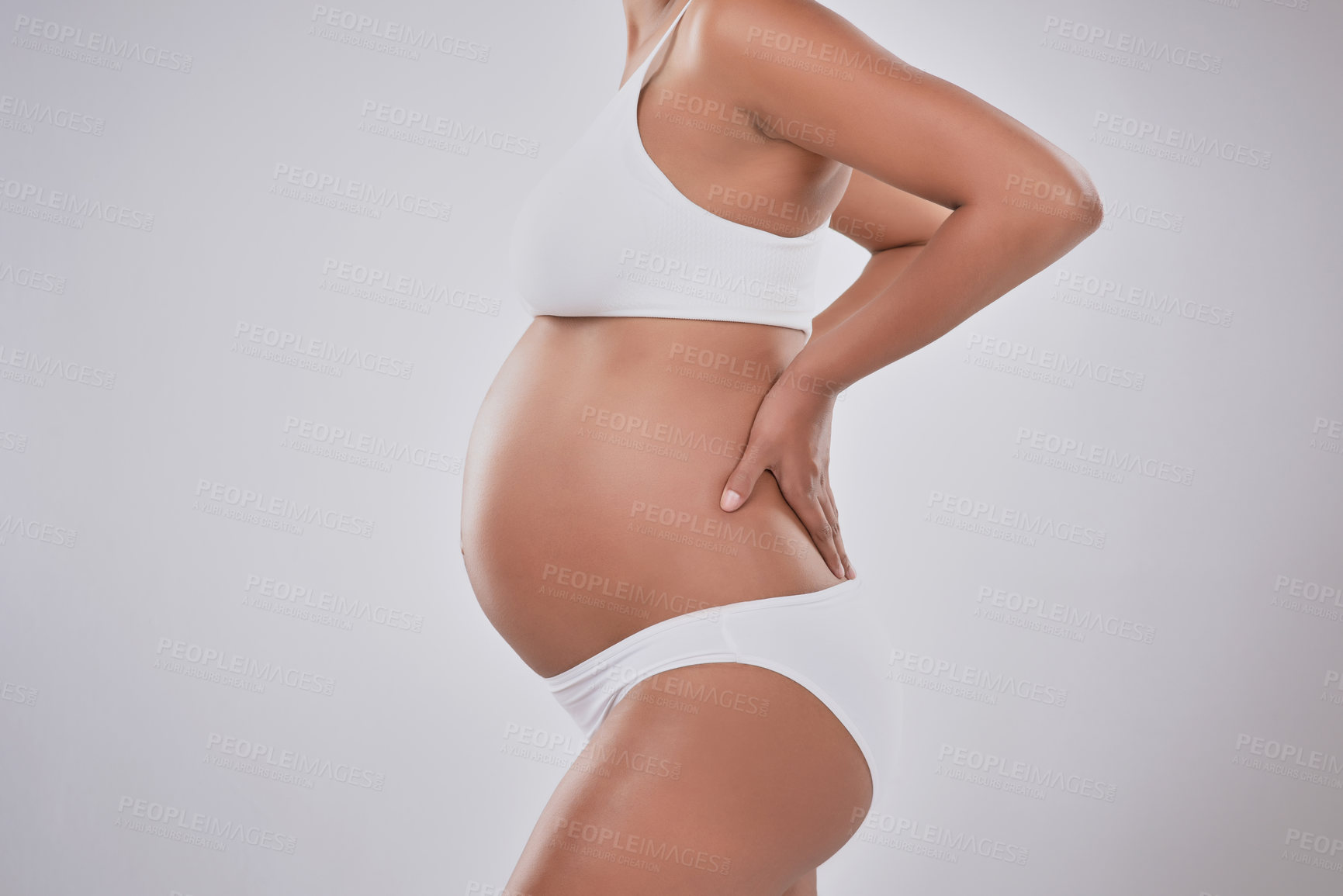 Buy stock photo Stomach, shape and pregnant woman in studio with skincare, wellness and body development in maternity. Pregnancy, growth and girl with self care for stretch marks, healthy skin and white background