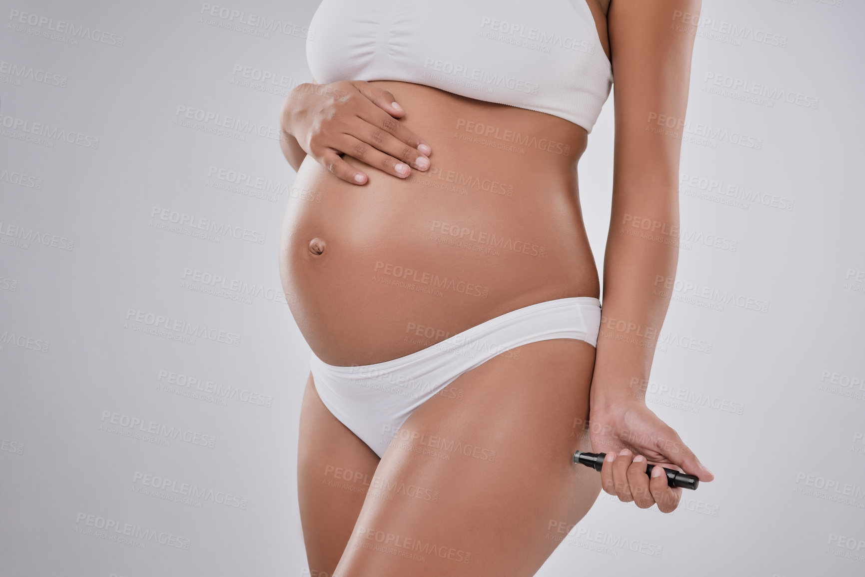 Buy stock photo Cropped studio shot of a pregnant woman using a blood sugar test against a gray background