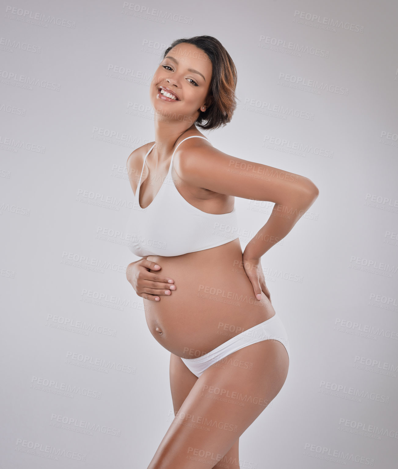 Buy stock photo Smile, portrait and pregnant woman in studio for health, wellness and body development in maternity. Pregnancy, stomach shape and happy girl with self care for growth, confidence and white background