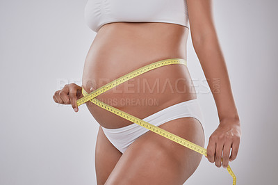 Buy stock photo Hands, measuring tape and pregnant woman in studio for stomach, growth and development by white background. Person, mother and check numbers with belly, abdomen and progress for prenatal wellness