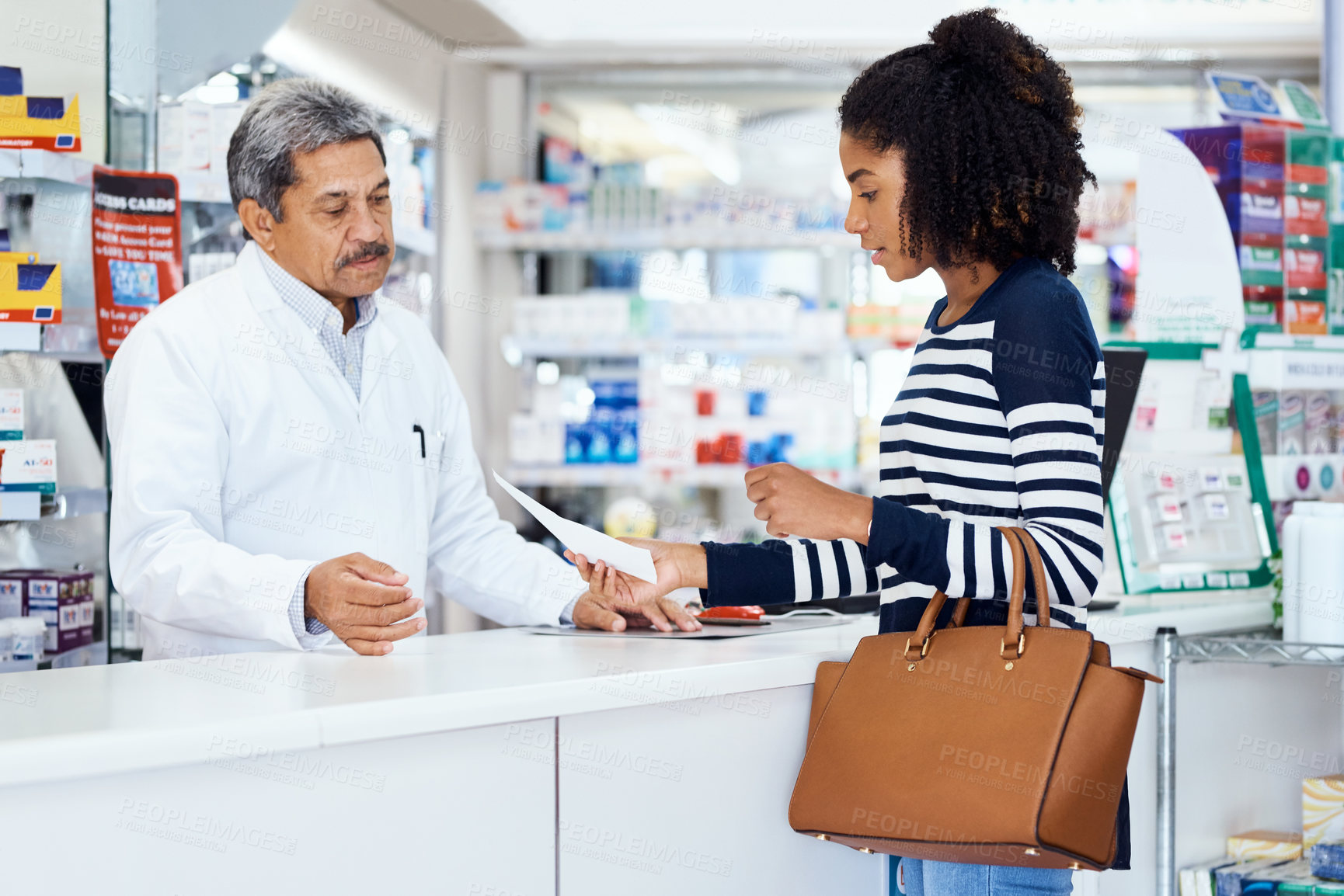 Buy stock photo Shot of a pharmacist assisting a young woman in a chemist