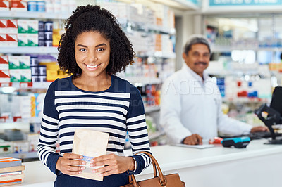 Buy stock photo Portrait of a young woman standing in a chemist with a pharmacist in the background