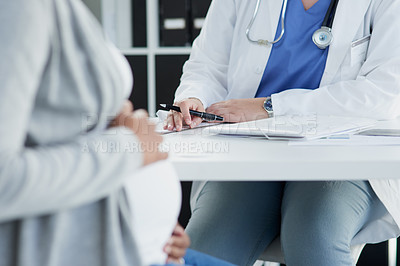 Buy stock photo Shot of an unrecognizable female doctor consulting with a pregnant patient at a hospital during the day