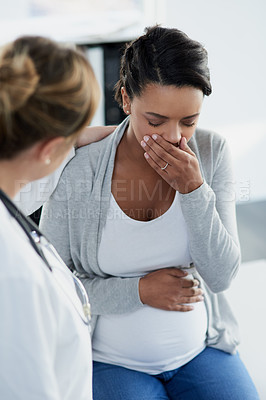 Buy stock photo Shot of a confident female doctor trying to comfort a distressed pregnant patient at a hospital during the day