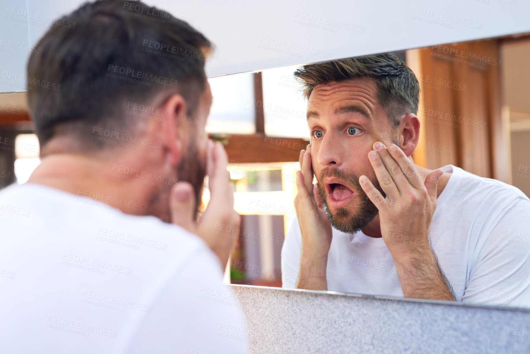 Buy stock photo Shot of a handsome young man going through his morning routine at home