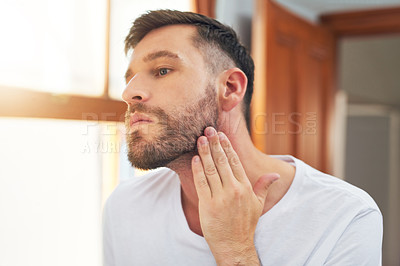 Buy stock photo Shot of a handsome young man going through his morning routine at home