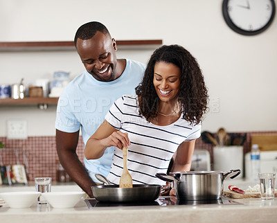 Buy stock photo Cropped shot of a young married couple cooking together in the kitchen at home