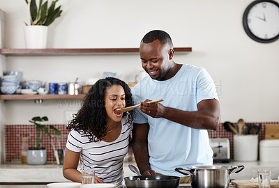 Buy stock photo Cropped shot of a young married couple cooking together in the kitchen at home
