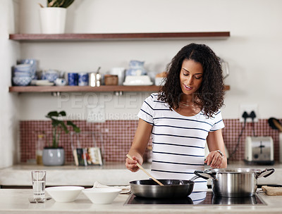 Buy stock photo Cropped shot of a young attractive woman cooking in the kitchen at home