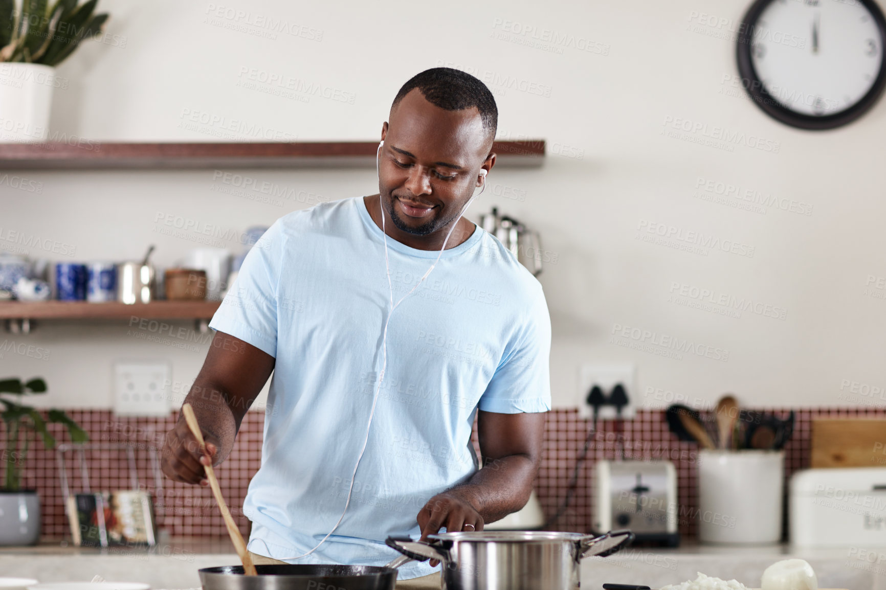 Buy stock photo Cooking, music and stove with man in kitchen of home for diet, health or nutrition recipe. Food, ingredients and vegetables with happy African person stirring pot, earphones and meal preparation