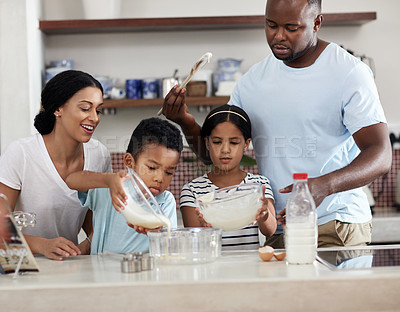 Buy stock photo Cropped shot of a young family baking together in the kitchen at home