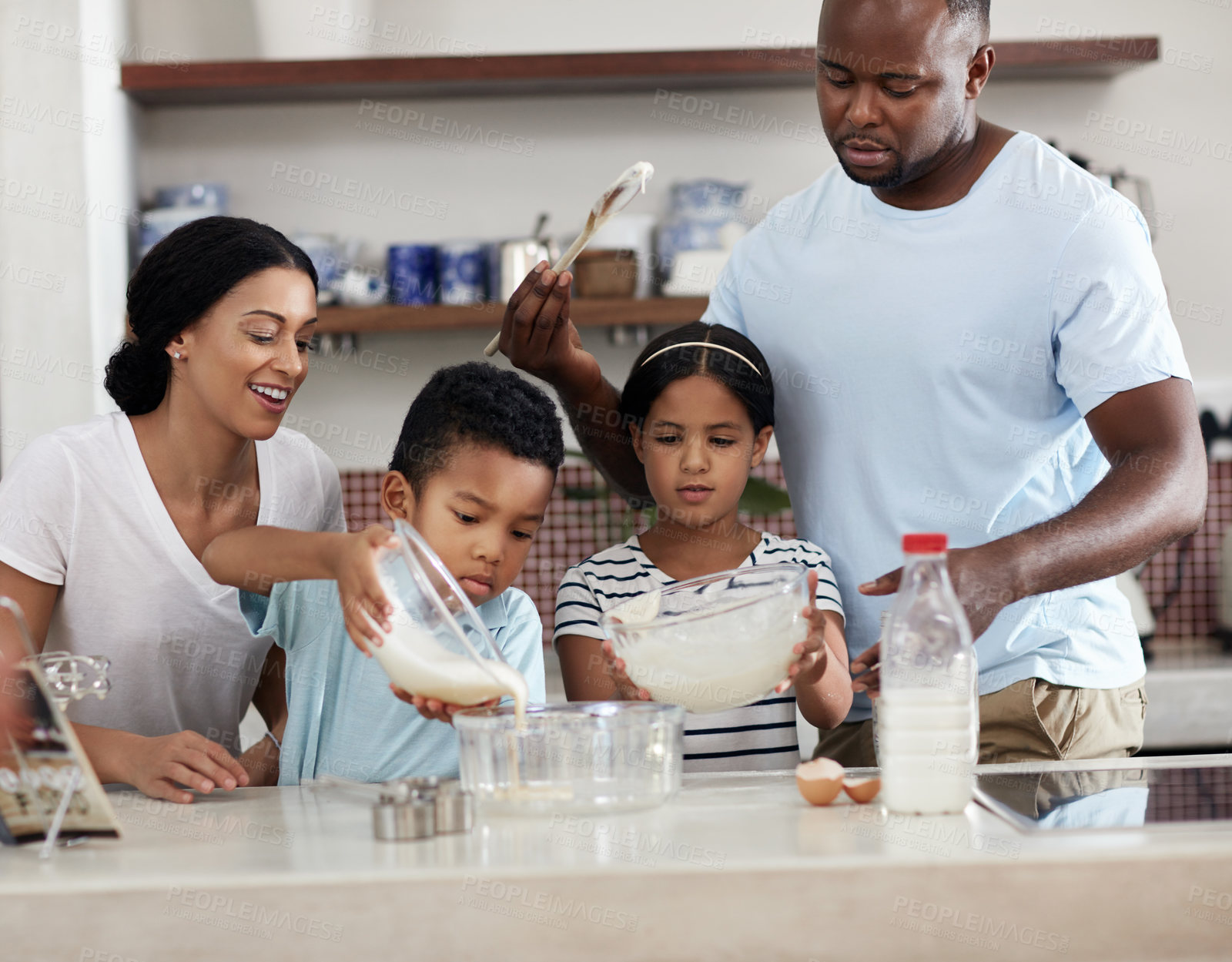 Buy stock photo Cropped shot of a young family baking together in the kitchen at home