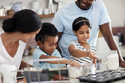 Buy stock photo Cropped shot of a young family baking together in the kitchen at home