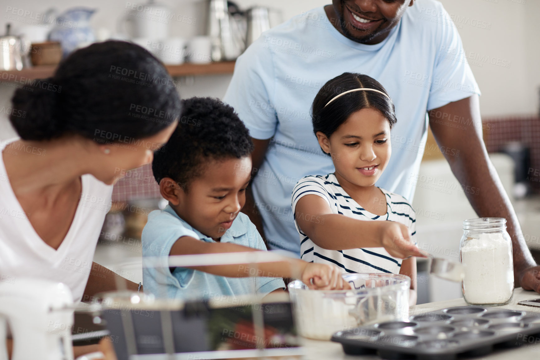 Buy stock photo Cropped shot of a young family baking together in the kitchen at home