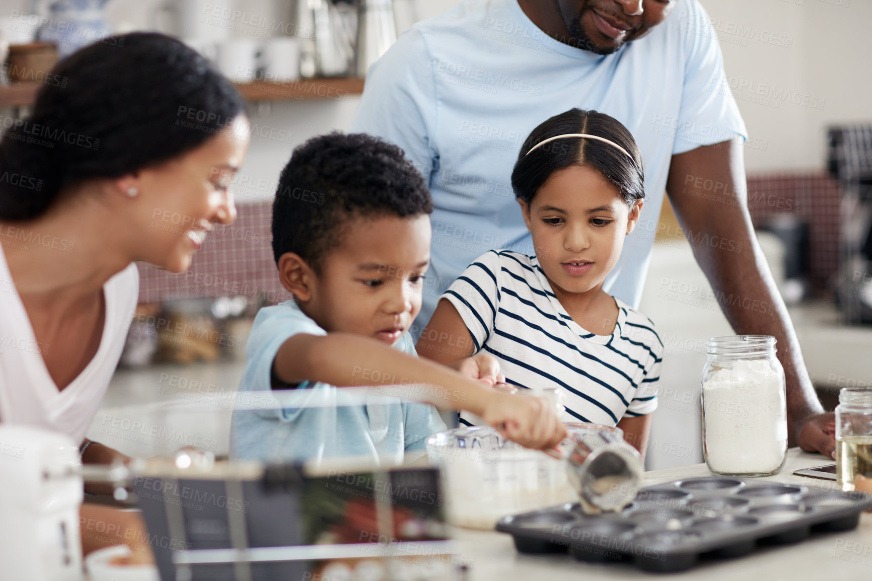 Buy stock photo Cropped shot of a young family baking together in the kitchen at home