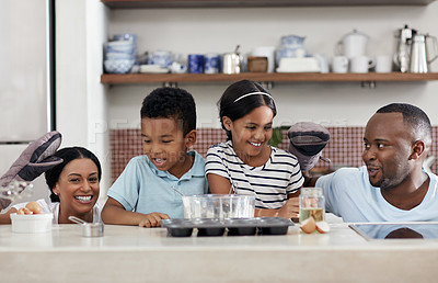 Buy stock photo Cropped shot of a young family baking together in the kitchen at home