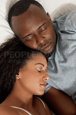 Buy stock photo Shot of a tired young couple sleeping comfortably together in their bed at home in the morning