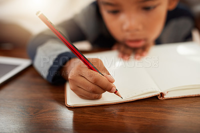 Buy stock photo Cropped shot of a young boy doing his homework