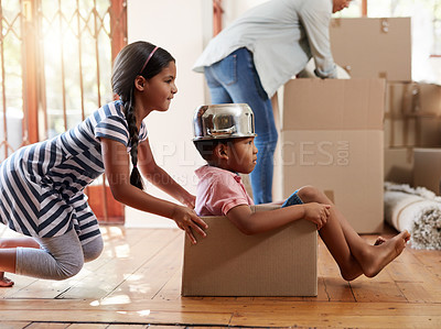 Buy stock photo Shot of two little siblings playing with a cardboard box while moving house