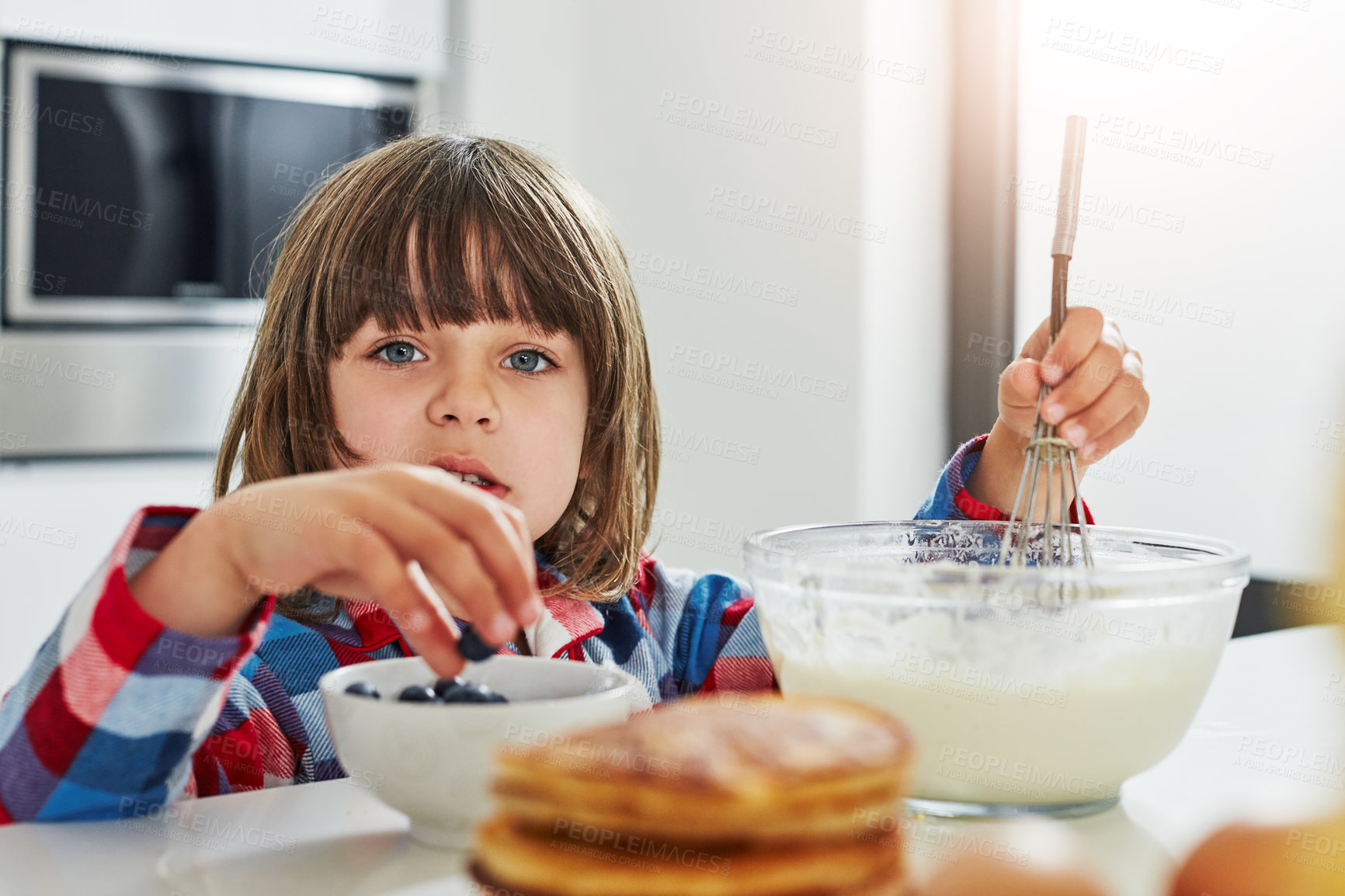 Buy stock photo Cropped shot of an adorable little boy making pancakes in the kitchen at home