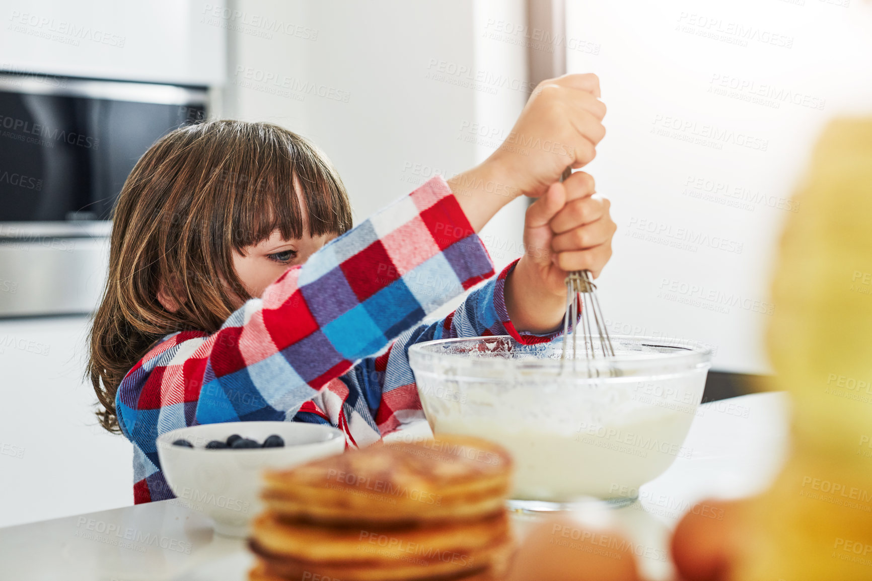 Buy stock photo Cropped shot of an adorable little boy making pancakes in the kitchen at home