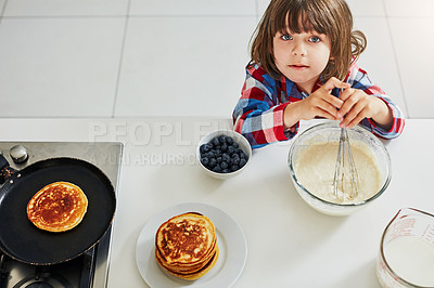 Buy stock photo High angle shot of an adorable little boy making pancakes in the kitchen at home