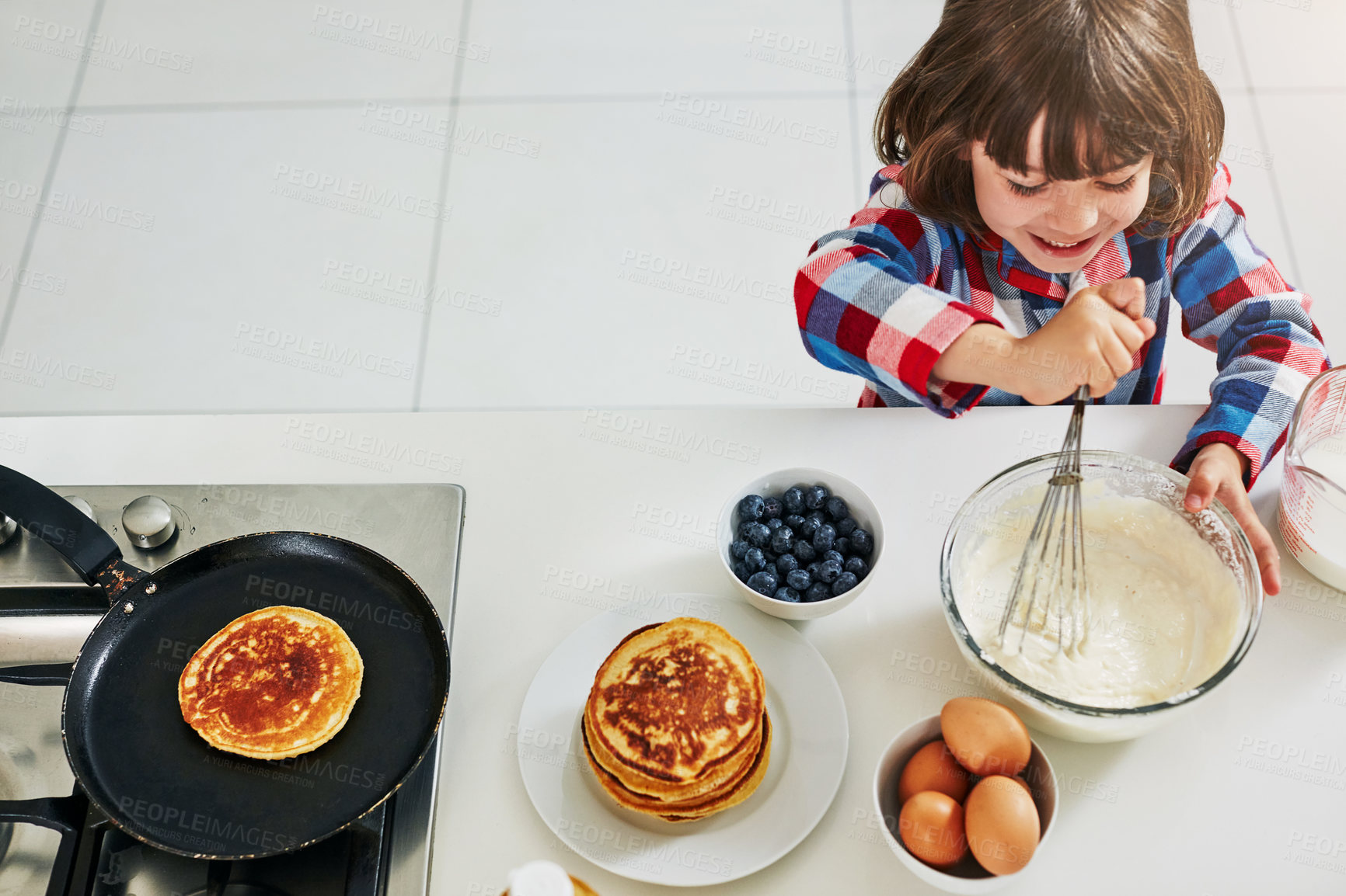 Buy stock photo Boy, baking and above in kitchen mixing, ingredients and happy bowl or pancake batter in morning apartment. Culinary skills, kid and mixture or cooking breakfast, child development and healthy recipe