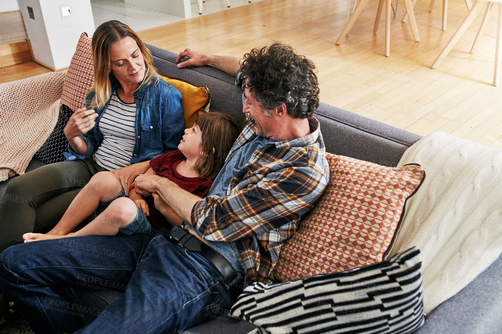 Buy stock photo Mom, dad and kid relax on couch in living room for love, care and quality time together in happy family home. Young boy, child and loving parents in lounge for support, bonding and happiness on sofa