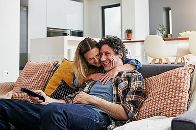 Buy stock photo Happy, couple and hug for watching tv in home, cable movies and news show of film media in lounge. Mature man, woman and love with television remote, subscription and connection to streaming platform