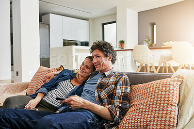 Buy stock photo Happy couple, relax and watching tv on living room sofa for news, cable show and media connection at home. Mature man, woman and hug with television remote, video subscription and streaming platform